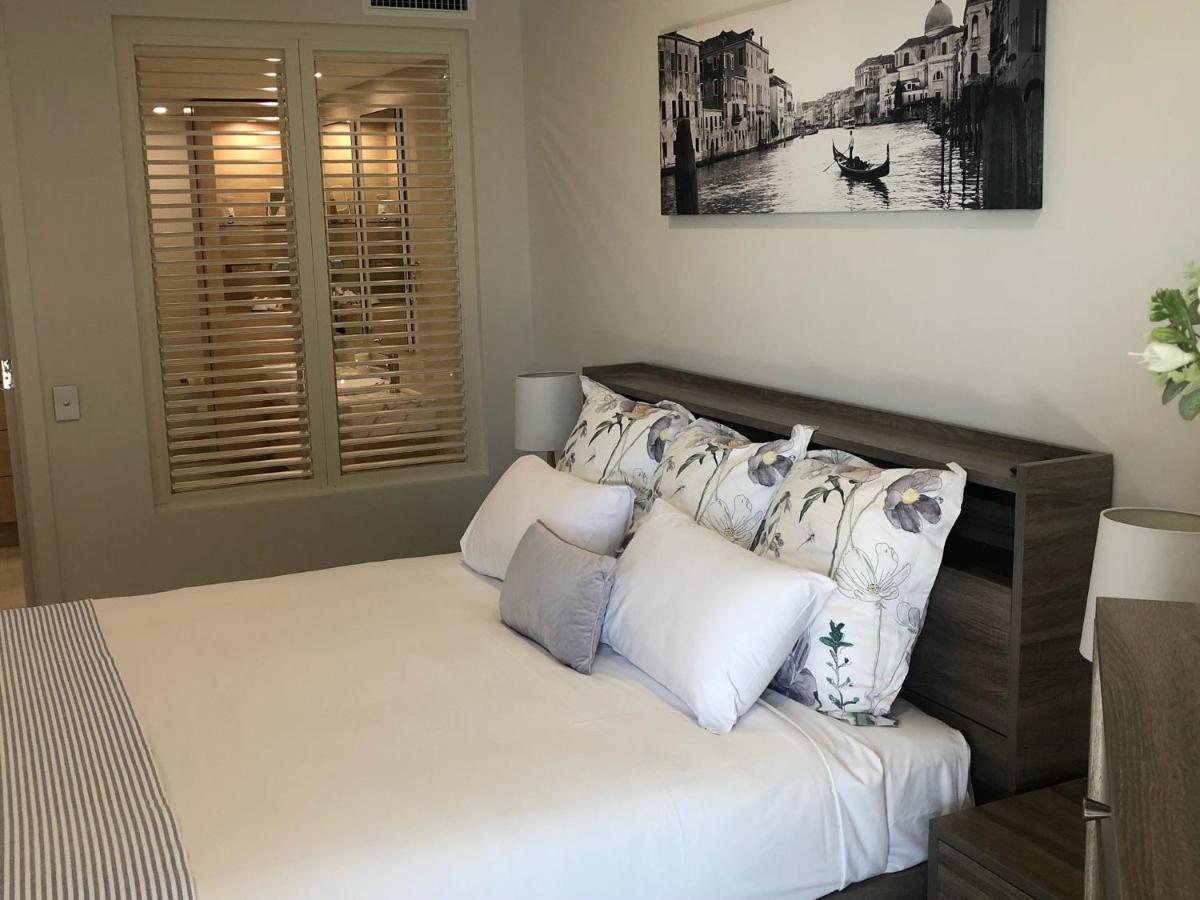 Grand Mercure Allegra Χέρβεϊ Μπέι Εξωτερικό φωτογραφία A bedroom with plantation shutters